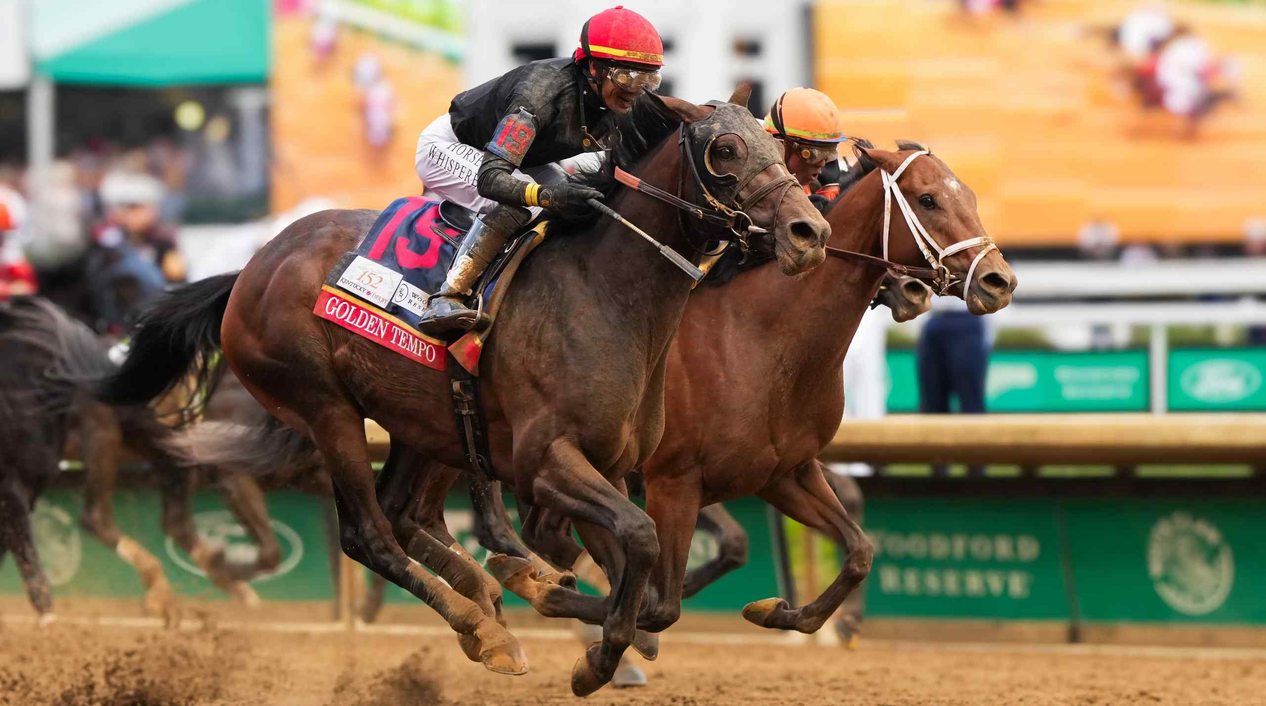 Two horses and jockeys neck and neck in a horse race.
